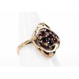 A 9ct gold garnet dress ring, the central cluster set with seven garnets, in Art Nouveau style, with