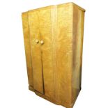 An Art Deco birds eye maple double wardrobe, the two doors opening to reveal a hanging rail flanked