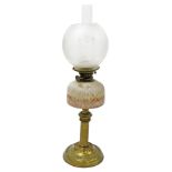 A Victorian brass oil lamp, with a pink frosted glass reservoir, glass chimney and frosted glass sha
