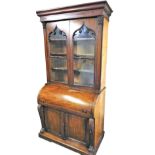 An early Victorian mahogany bureau bookcase, the outswept pediment over a pair of glazed Gothic arch