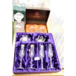 A set of four rock crystal champagne flutes and candle holders, boxed, a pair of Webb lead crystal b