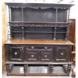 A late 19th/early 20thC oak dresser, the raised back with spirally turned supports, floral carved