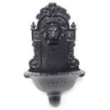 A cast resin wall mounted fountain, decorated with a lion mask, 63cm high.