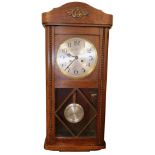 An early 20thC oak cased wall clock, with silvered 19cm Arabic dial, in a fitted case with visible