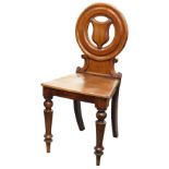 A Victorian mahogany hall chair, the circular back inset with a shield with a solid seat on turned