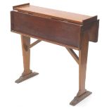 A teak ship's drop leaf table, with a raised gallery on end supports with brass mounts for bolts