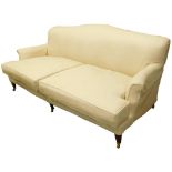 A mahogany three seater sofa, with cream upholstery, on square tapering legs with castors, in the