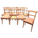 A set of eight Regency mahogany dining chairs, each with a bar back and cane seat on sabre legs.