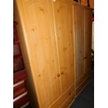 A pair of pine effect wardrobes.