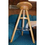 A beech tripod stool, with height adjustable seat.