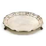 A George V silver pie crust salver, raised on three ball and claw feet, S. Blanckensee & Son Ltd, Bi