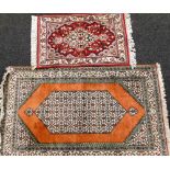 A Persian type rug, decorated with a pearl medallion, on an orange ground with multiple borders and