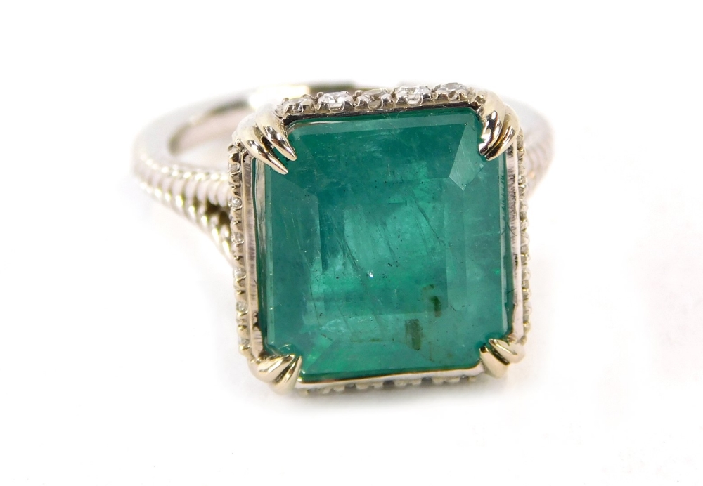 An emerald and diamond dress ring, with octagonal step cut emerald, measuring 12.10 x 11.11 x 8.77mm