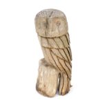 A carved driftwood figure of a seated owl, on perch, 60cm high.