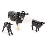 Three Beswick cow ornaments, comprising a modern Beswick Holstein cow, and two Beswick calves. (3)