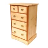 A stripped pine chest of drawers, with two short and three long drawers, with brass scroll handles,