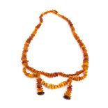A Baltic amber necklace, of modern form with two twist central section and two drop pendants, with l
