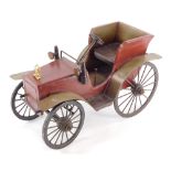 A model car, the main body made of wood, painted red, with metal applied supports, 30cm high, 44cm w