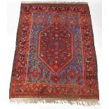 A Persian rug, with a central large pole medallion in deep red, on a blue ground with multiple borde