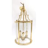 An early 20thC brass lantern, with arched top and three branch candelabrum interior, with four glass