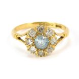 An Edwardian 18ct gold cluster ring, with central circular aquamarine, surrounded by tiny diamonds,