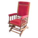 An early 20thC American walnut and upholstered rocking chair, with red upholstery, 113cm high, 55cm