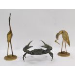 A pair of brass oriental storks, 32cm and 24cm high, and a cast figure of a crab, 20cm wide.