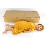A German bisque headed doll, stamped AS German 82, 3, in a yellow dress, with wooden limbs, 16cm lon