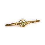 A peridot and seed pearl bar brooch, the central two twist circular emblem, with diamond shaped pane