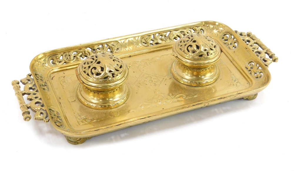 A late 19thC French brass inkwell, the rectangular tray with scroll leaf design, with two hinged bra