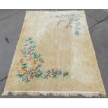 A Chinese cut wool rug, on a cream ground with pink flowers and leaves, with tassel ends, 390cm x 28