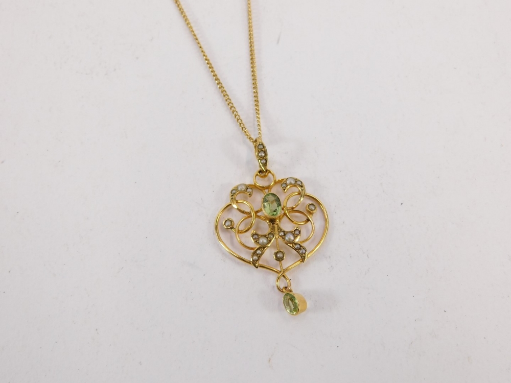 An Art Nouveau pendant and chain, the scroll design pendant set with seed pearl and peridot, 4cm hig