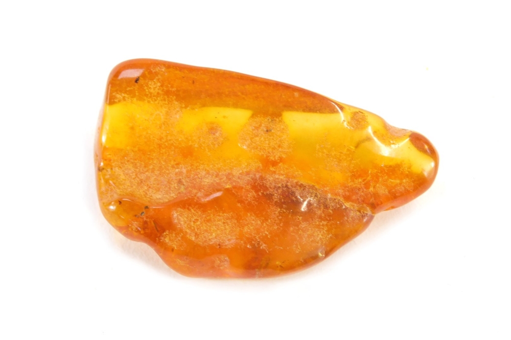 A piece of natural amber, with various growth specks and rubbed detailing, 5cm wide, 12.4g all in.