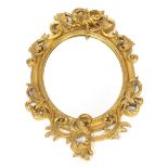 An early 20thC gilt gesso wall mirror, with rococo scrolled outer detailing and intertwined cherub f