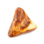 An amber bead, triangle rough cut with two tone colouring.