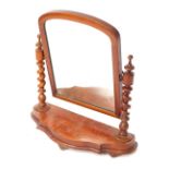 A Victorian mahogany swing framed toilet mirror, raised on turned and spiral twist columns, over a s