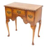 A Georgian style walnut lowboy, with one short and two deep drawers above a shaped apron, raised on
