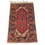 A Persian rug, decorated with three star shaped medallions on a red ground, with cream spandrels and