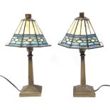 A pair of Tiffany style table lamps, each with a cream and blue shade, on brushed and polished brass