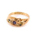 A 9ct gold gypsy ring, set with three blue coloured stones and two CZ with scroll design shoulders,