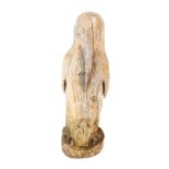 A carved driftwood figure of a penguin and child, 92cm high.
