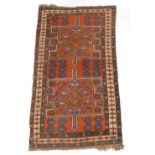A Persian rug, with two geometric multi coloured compartments, on an orange ground with multiple bor