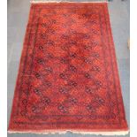 A Belouch type rug, with a design of medallions on a deep orange ground with multiple borders, 326cm