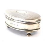 A George V silver oval dressing table box, with engine turned decoration, vacant oval reserve to lid