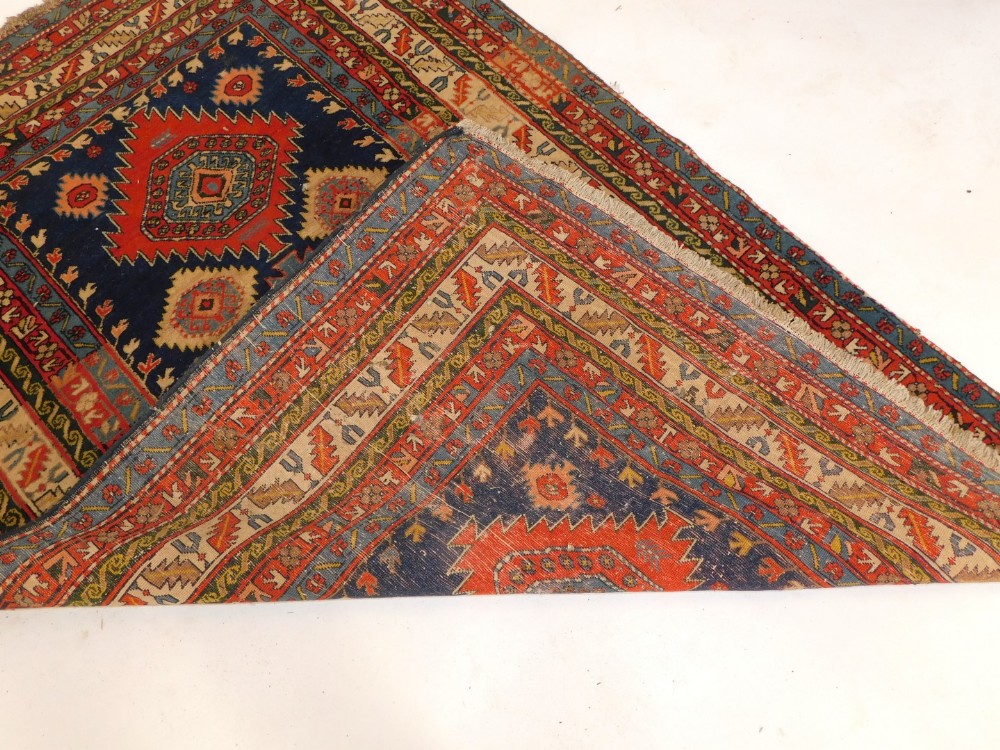 A Persian Kazak type rug, with three geometric medallions in deep orange and pale blue, on a blue gr - Image 3 of 3