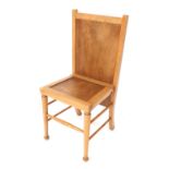 An Arts & Crafts style light beech chair/trouser press, with solid seat and back, raised on turned l