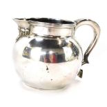 A silver milk or water jug, with a scroll handle and heart shaped thumb press, London 1978, 7¼oz.