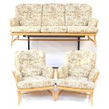 An Ercol light elm and beech Windsor three piece suite, comprising three seater sofa with floral uph