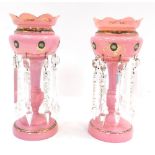 A pair of Victorian pink glass lustres, each with a fluted top applied with gilt detailing and cryst