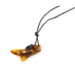 A novelty amber shoe necklace, the piece of amber shaped into a boot and polished and pieced with bl